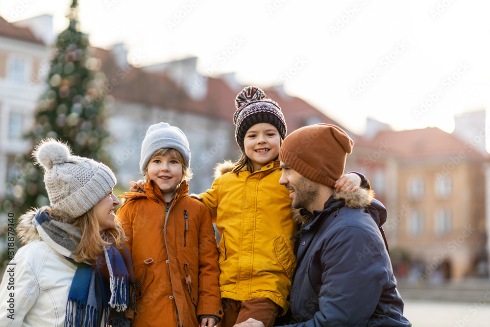 Happy young family having fun outdoors during Christmas 
