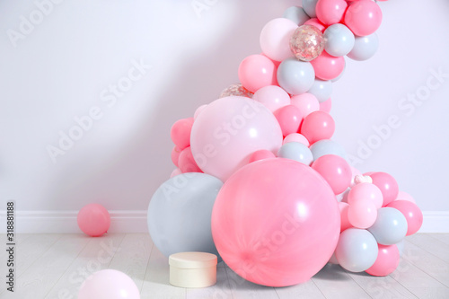 Beautiful composition with balloons near light wall