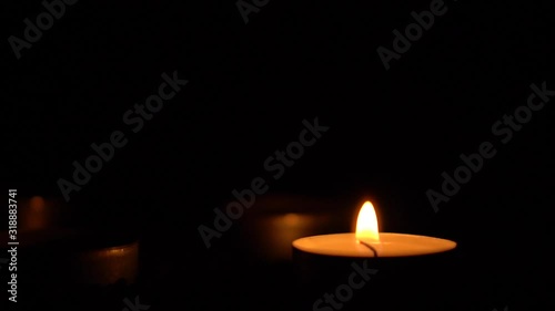 Slow motion white candles light up flames fire on isolated black background. Use in romantic dinner, warm and relax peace maditaion, use for spiritual religion church decotion and Halloween graveyard photo