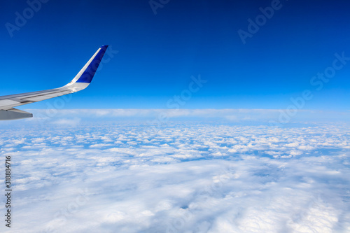 Airplane wing and beautiful blue sky with white clouds
