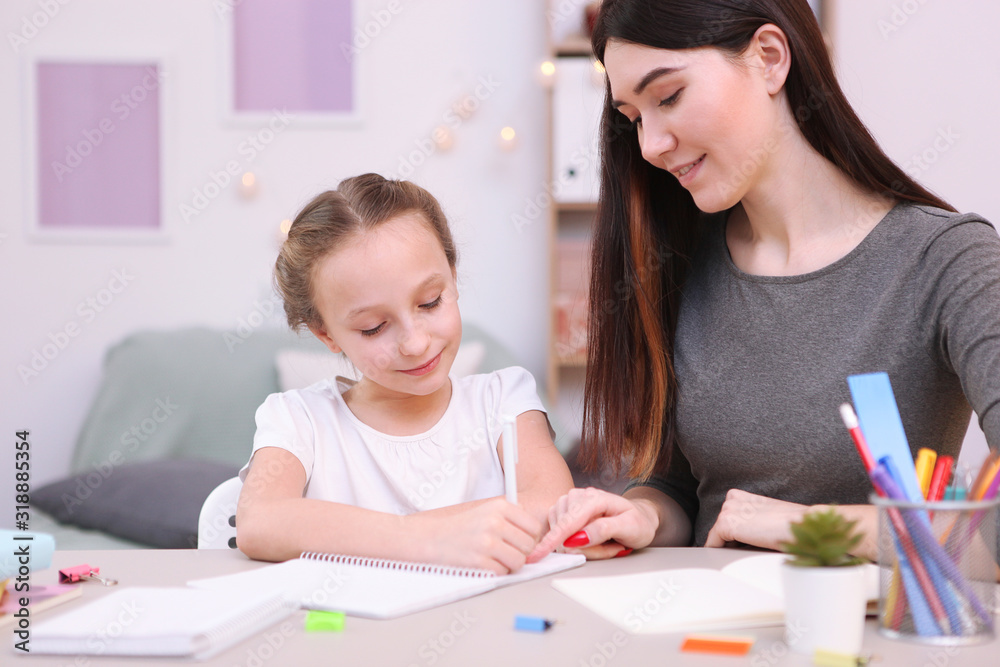 Mom helps the girl to do homework. Children and parents. Mom helps the girl to do homework. Children and parents.