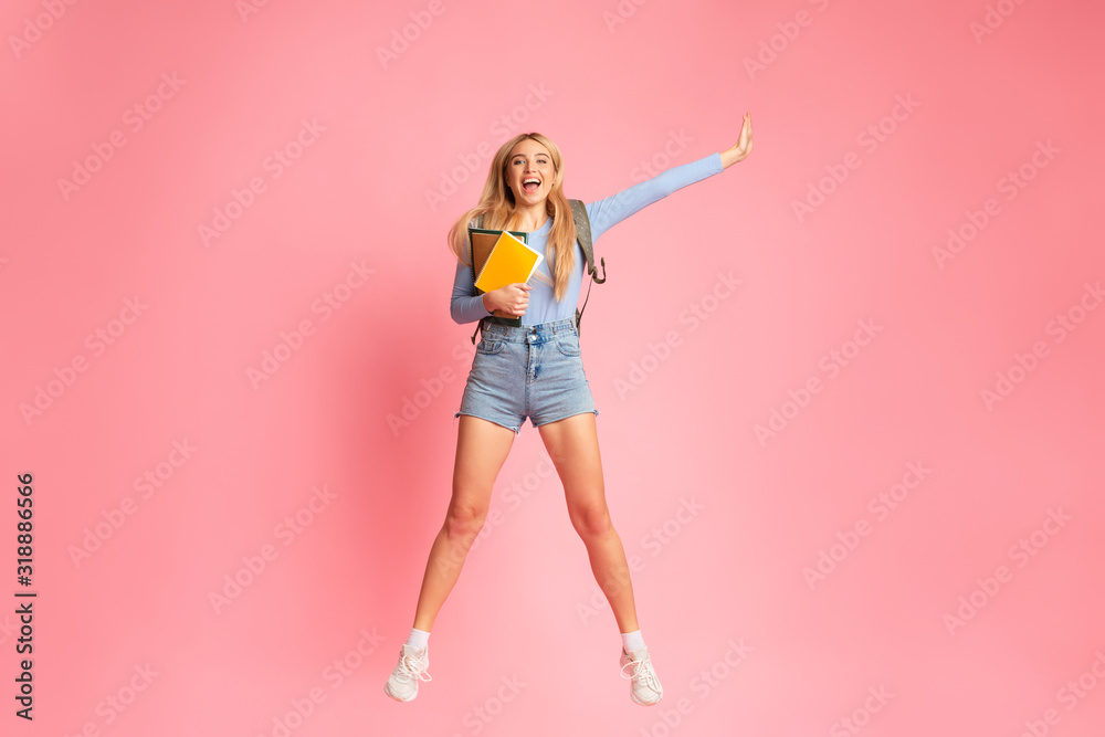 Cheering teen girl jumping over pink wall Stock Photo | Adobe Stock
