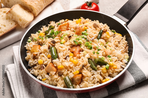Delicious rice pilaf with vegetables on table