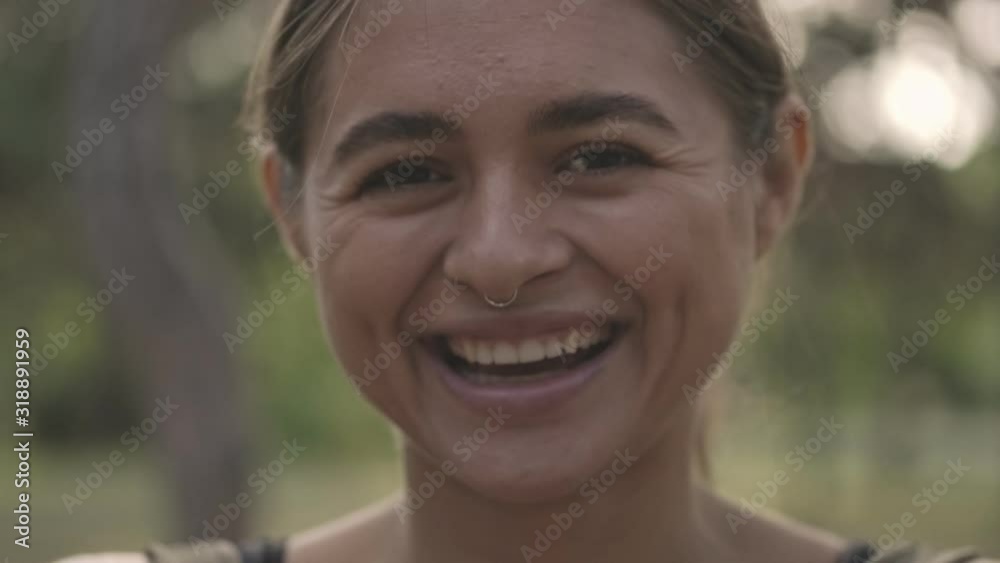 Close up view of cheerful brunette sports woman looking at the camera in park outdoors Close up view of cheerful brunette sports woman looking at the camera in park outdoors