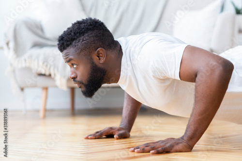 Young black man doing push ups, side view