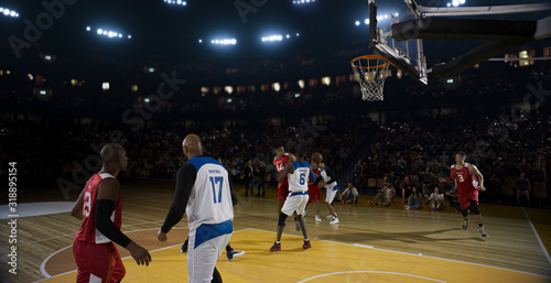 Basketball players on big professional arena during the game. Tense moment of the game. © haizon