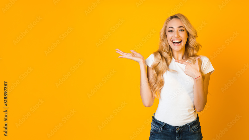 Overjoyed girl pointing finger at open palm, free space