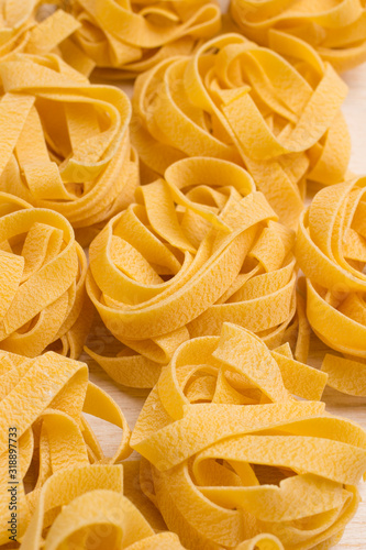 Raw wheat pasta on white background