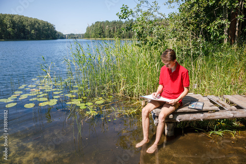 Teen boy sketching summer landscape with pastel sticks