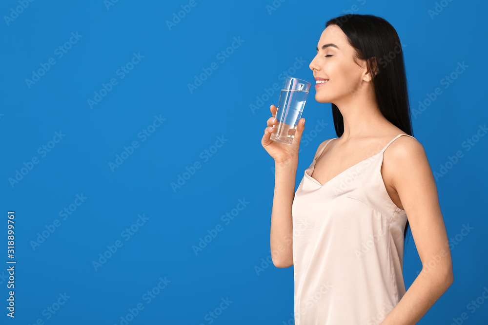 Beautiful young woman with glass of water on color background Beautiful young woman with glass of water on color background