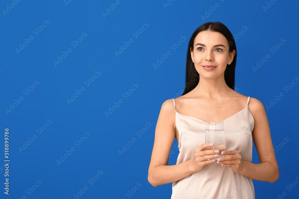 Beautiful young woman with glass of water on color background Beautiful young woman with glass of water on color background