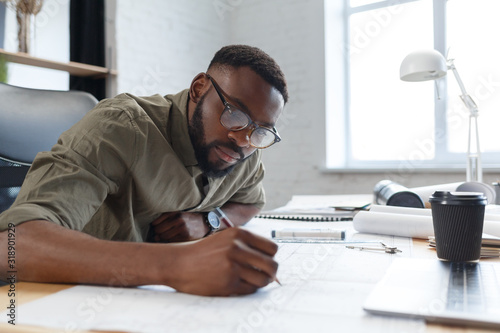 Fotografie Afro-American architect working in office with blueprints