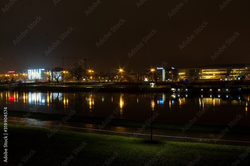 Panorama of the Polish city of Krakow, the cultural capital of Poland, with architecture glowing with bright night lights in the winter.