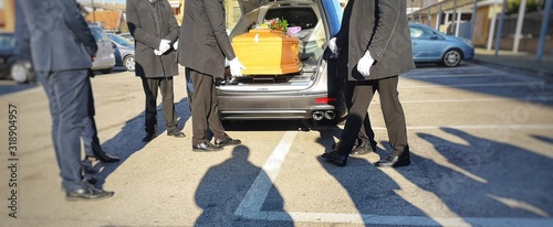 Gravediggers put coffin into car photo