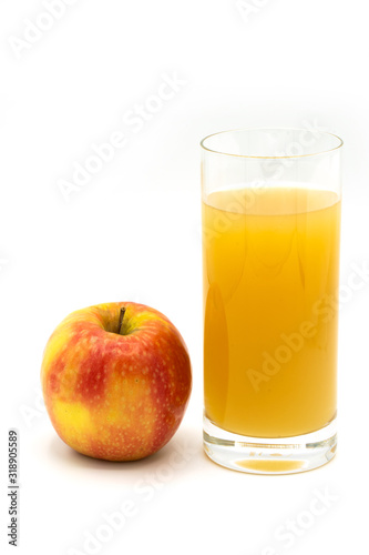 naturally cloudy apple juice - yellow, ​red apples with drops of water and a glass of naturally cloudy apple juice in front of white background