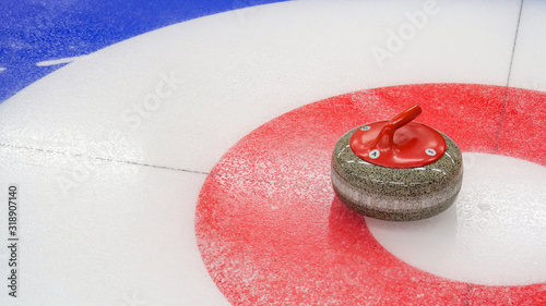 Curling winter, olympic sport.Curling stone and  Ice curling sheet with red and blue circle and visible pebbles 