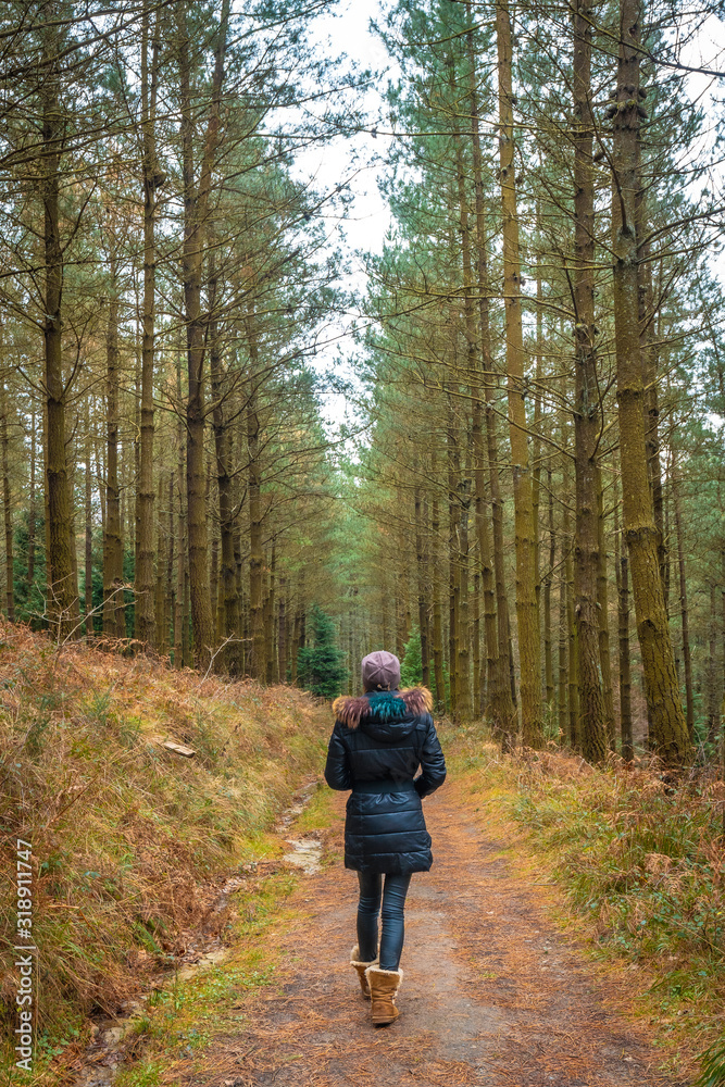 Obraz premium Blonde girl on the path of the Otzarreta Forest in Gorbea, Bizkaia. Spain