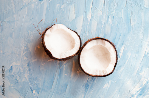 Two halves of coconut on a blue texture background