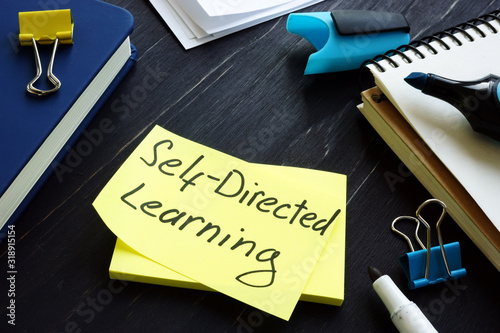 Self-directed learning or education concept. Book and notes with pen. photo