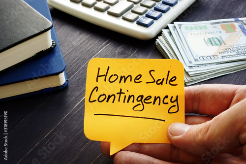 Realtor holds home sale contingency memo sign.