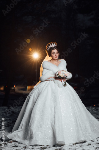 Fashion bride beautiful woman in wedding dress, vogue style model bridal luxury dress, wedding hairstyle and makeup, girl with crown. Beautiful bride with bouquet. Evening photoshoot