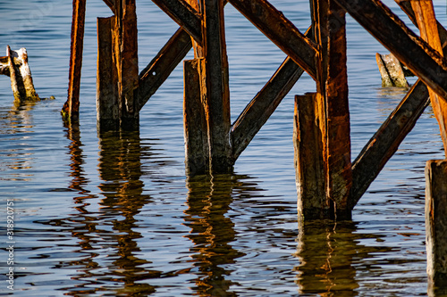 Very rusty metal frames, old thick metal subject to corrosion from salty seawater. Red bright color in sunlight