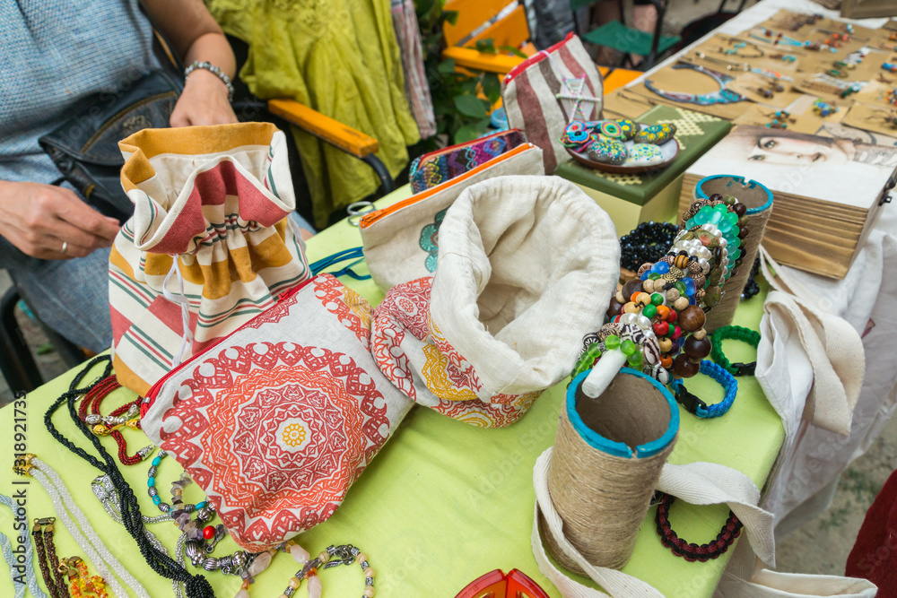 Handmade jewellery, accessories, and hand sewn cotton bags showcased on stall. Original items sold by local craftsmen and designers on a crafts and arts outdoor market in Chisinau, Moldova