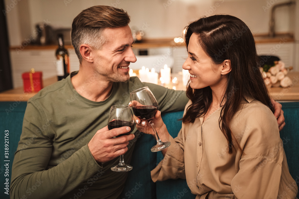 Image of couple drinking red wine while having romantic dinner at home Image of couple drinking red wine while having romantic dinner at home