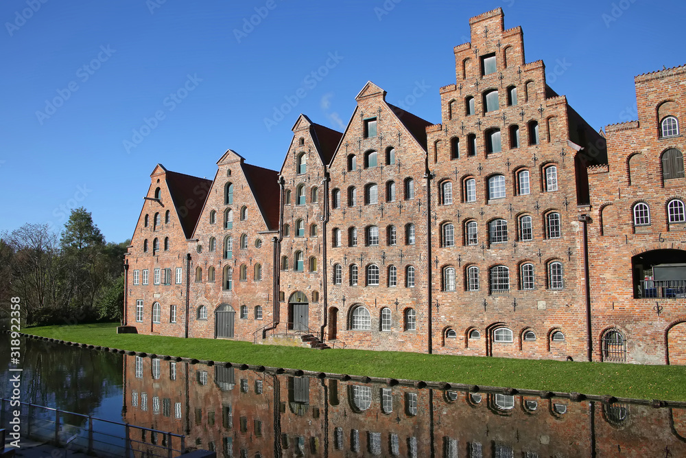 Six historic brick buildings that were used as salt storehouses on the Upper Trave River next to the Holstentor (the western city gate) of Lubeck, Germany.