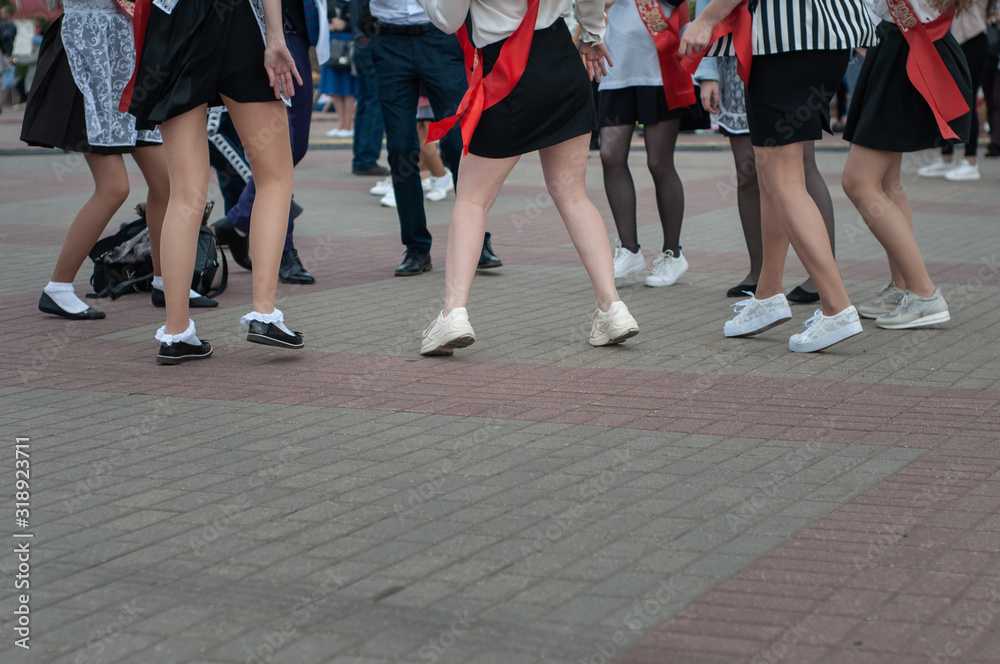 Girls high school graduates in school uniforms are dancing at the graduation parade. Last call. Girls high school graduates in school uniforms are dancing at the graduation parade. Last call.