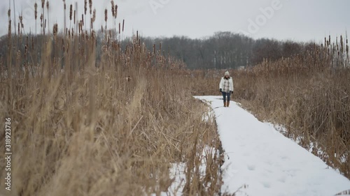 woman walking in winter in forest preserve photo