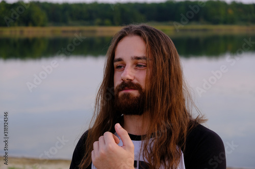Portrait of handsome bearded young man with long hair photo