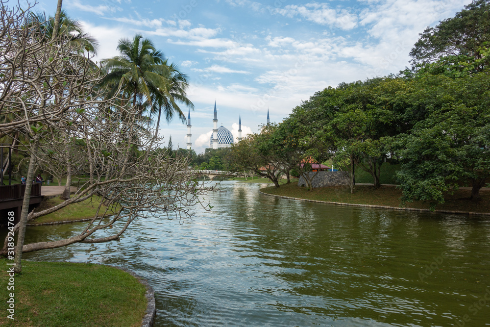Sultan Salahuddin Abdul Aziz Shah Mosque in Shah Alam, Malaysia during blue skies sunny day with Shah Alam lake in foreground. It is also known as Blue Mosque.