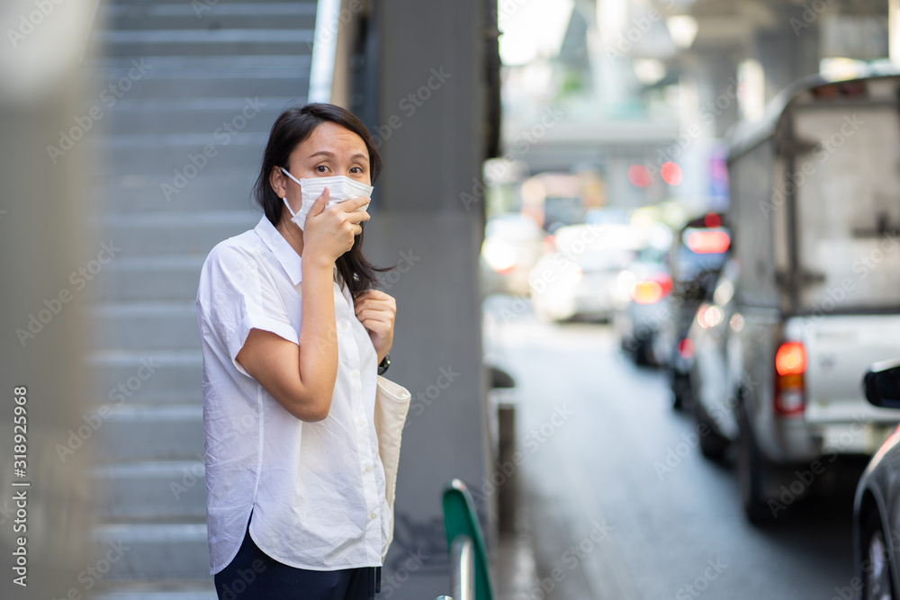 Woman wearing face mask protect filter against air pollution (PM2.5) or wear N95 mask. protect pollution, anti smog and viruses, Air pollution caused health problem. environmental pollution concept.