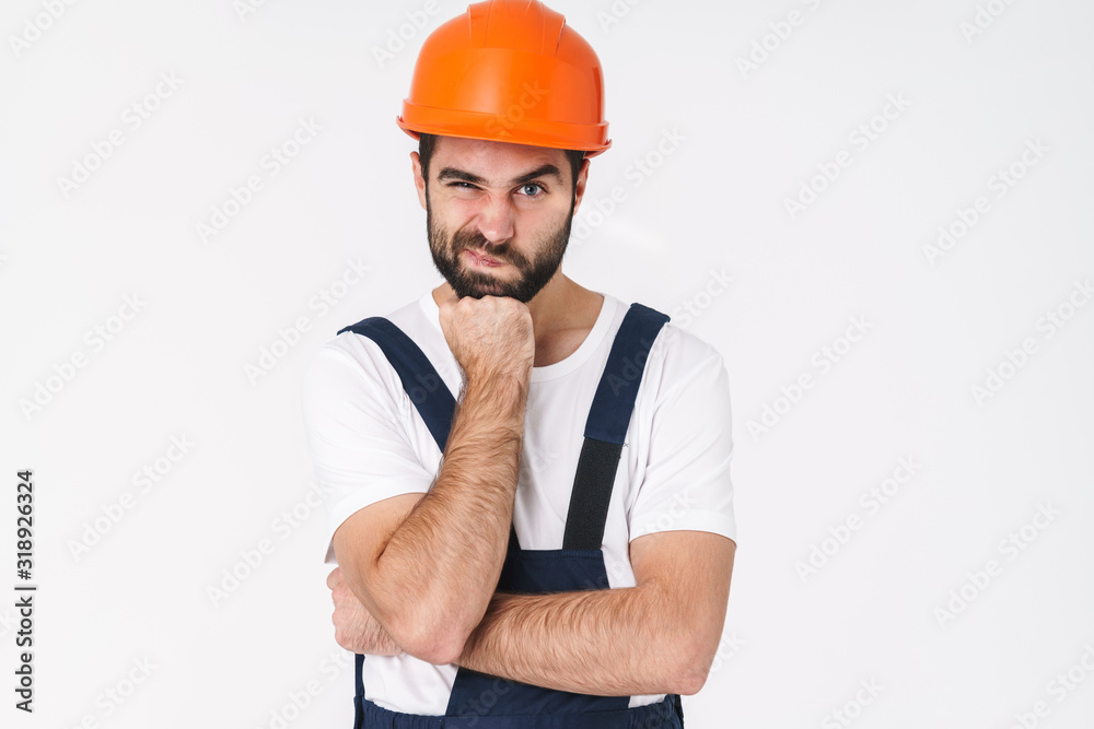 Young man builder in helmet posing isolated