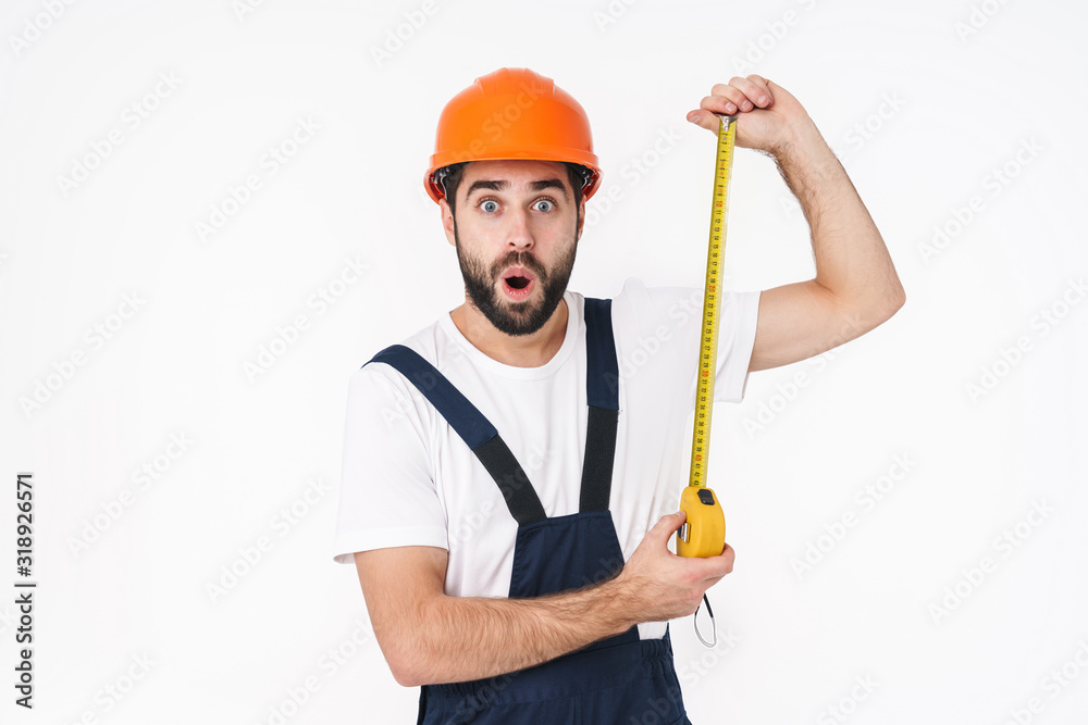 Shocked young man builder holding centimeter. Shocked young man builder holding centimeter.