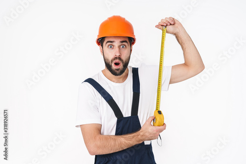 Shocked young man builder holding centimeter.
