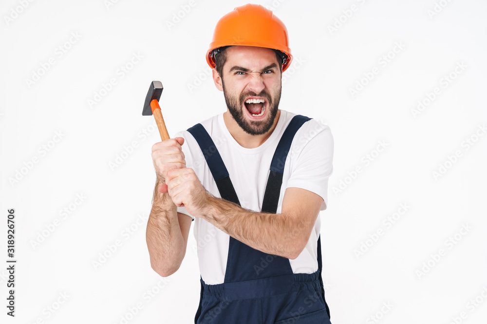 Emotional young man builder in helmet holding hammer.