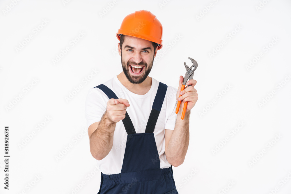 Happy young man holding plumbing wrench pointing to you. Happy young man holding plumbing wrench pointing to you.