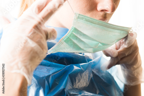 a woman wearing a hygiene mask and gloves is trying to avoid a coronavirus epidemic photo