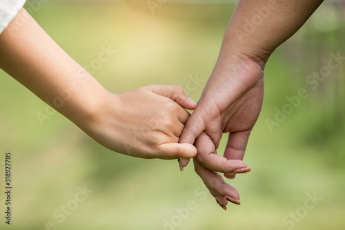 Couple holding hands are happy with blurred nature background.