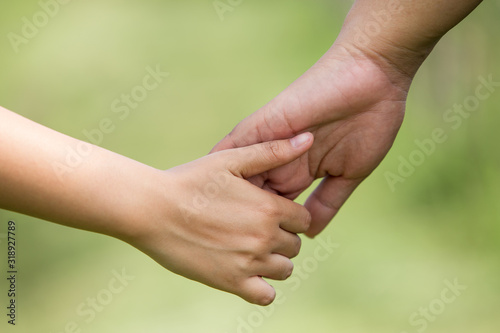 Couple holding hands with blurred nature background. Close-up © Pituk