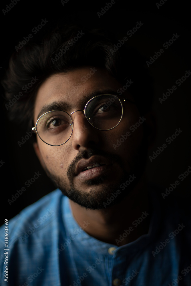 Fashion portrait of young and handsome Indian Bengali brunette man with traditional cotton wear and glasses in black copy space background. Indian lifestyle and fashion photography. Fashion portrait of young and handsome Indian Bengali brunette man with traditional cotton wear and glasses in black copy space background. Indian lifestyle and fashion photography.
