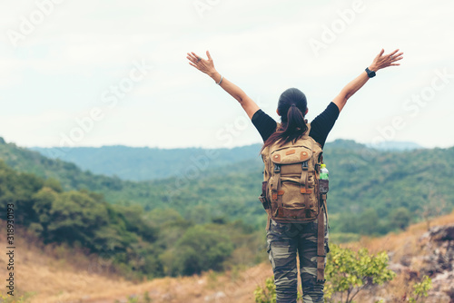 Hiker asian woman backpack raise hands happy feeling freedom good and strong weight victorious facing on the natural mountain. Traveler going camping outdoors destination leisure