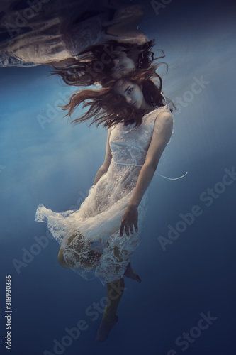 Portrait of a girl in a dress with lace underwater