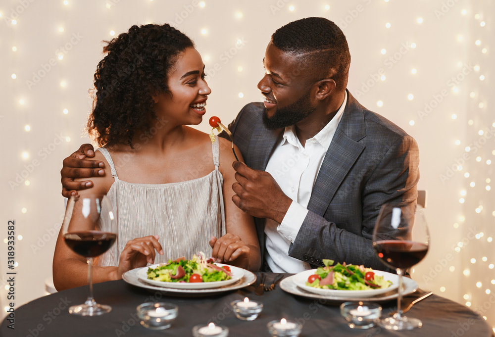 Couple in love feeding each other at restaurant Couple in love feeding each other at restaurant