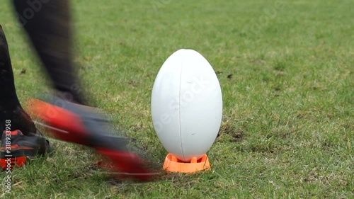 Kicking a conversion in Rugby. A player kicks the ball  off a tee during a match. Super Slow motion