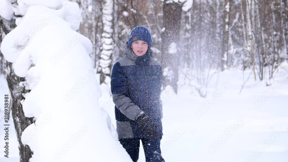 A child plays in the open air in winter, throws snow. Active outdoor sports.