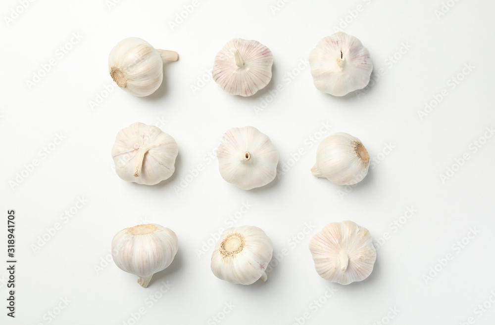 Flat lay with garlic bulbs on white background, top view