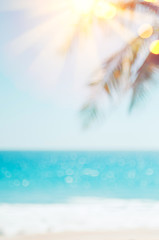 Blur beautiful nature green palm leaf on tropical beach with bokeh sun light wave abstract background.